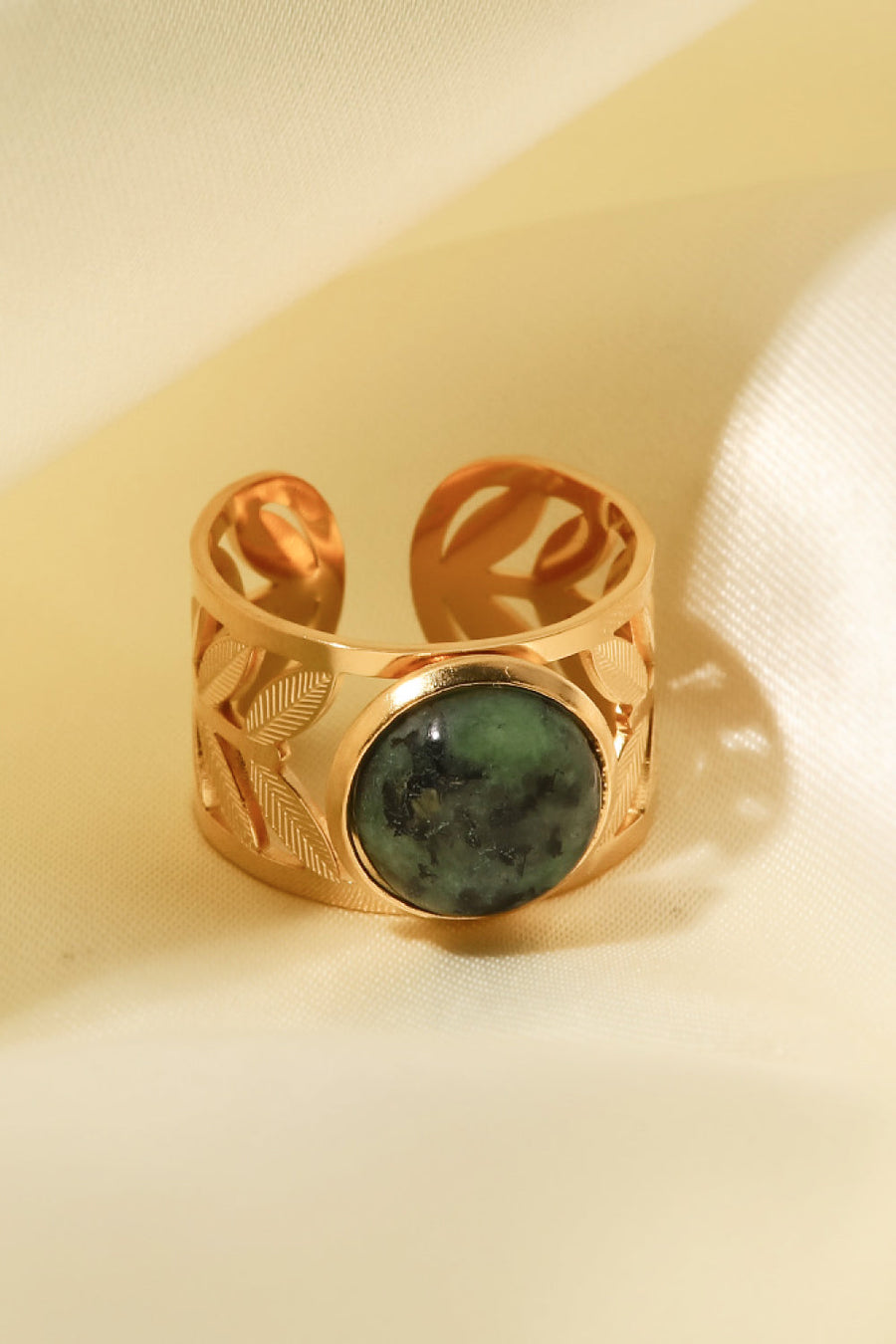 Gold ring with leaf cutouts and a malachite stone