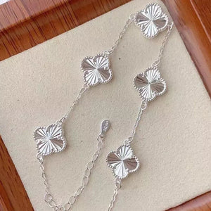 Silver bracelet featuring four-leaf clover charms and four-leaf clover