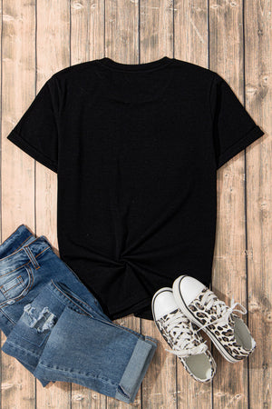 Black t-shirt with rolled sleeves and a twisted hem detail, styled with distressed jeans and leopard print sneakers.