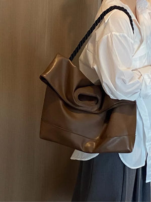 Oversized brown PU leather tote bag with twisted black strap and cutout handle