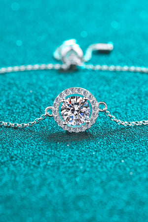 Silver adjustable bracelet with a round moissanite halo pendant.