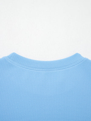 Textured blue blouse with crew neck and bubble sleeves