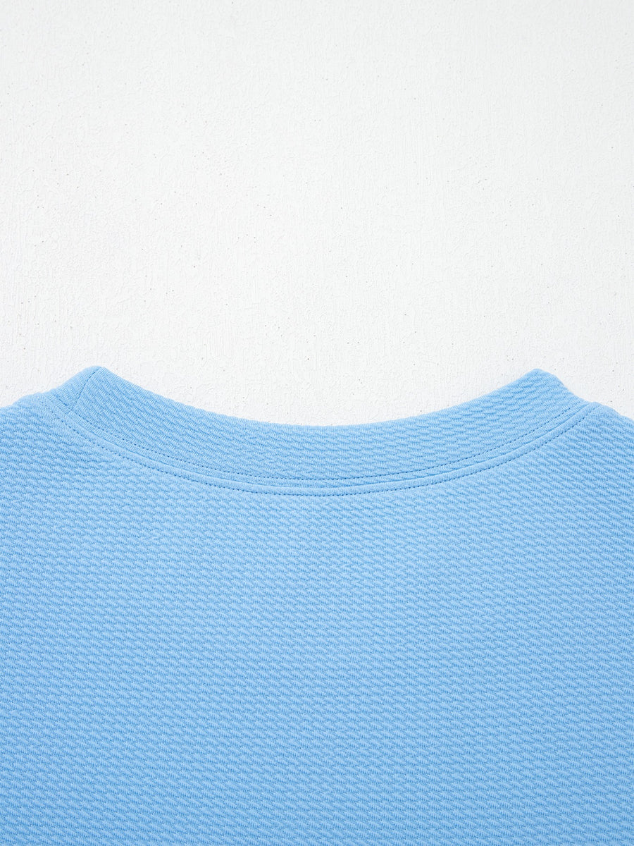 Textured blue blouse with crew neck and bubble sleeves
