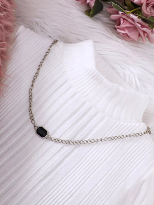 White ribbed dress with a silver chain necklace featuring a black gem detail.