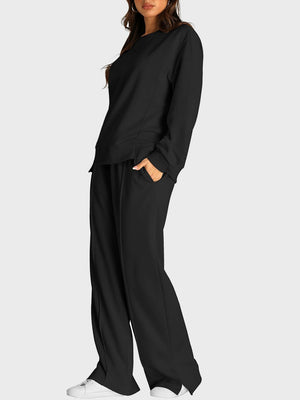 Black seamed loungewear set with crewneck top and slit-front wide-leg trousers.