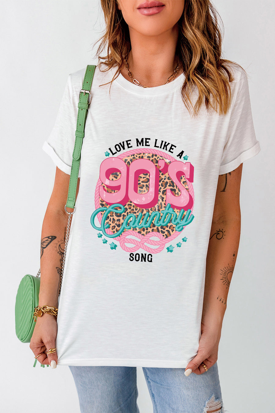 White graphic t-shirt with 90s country song design and leopard print detail.