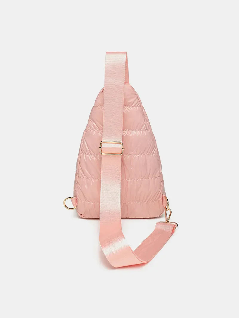 Glossy padded sling bag in pink with adjustable strap and gold hardware.