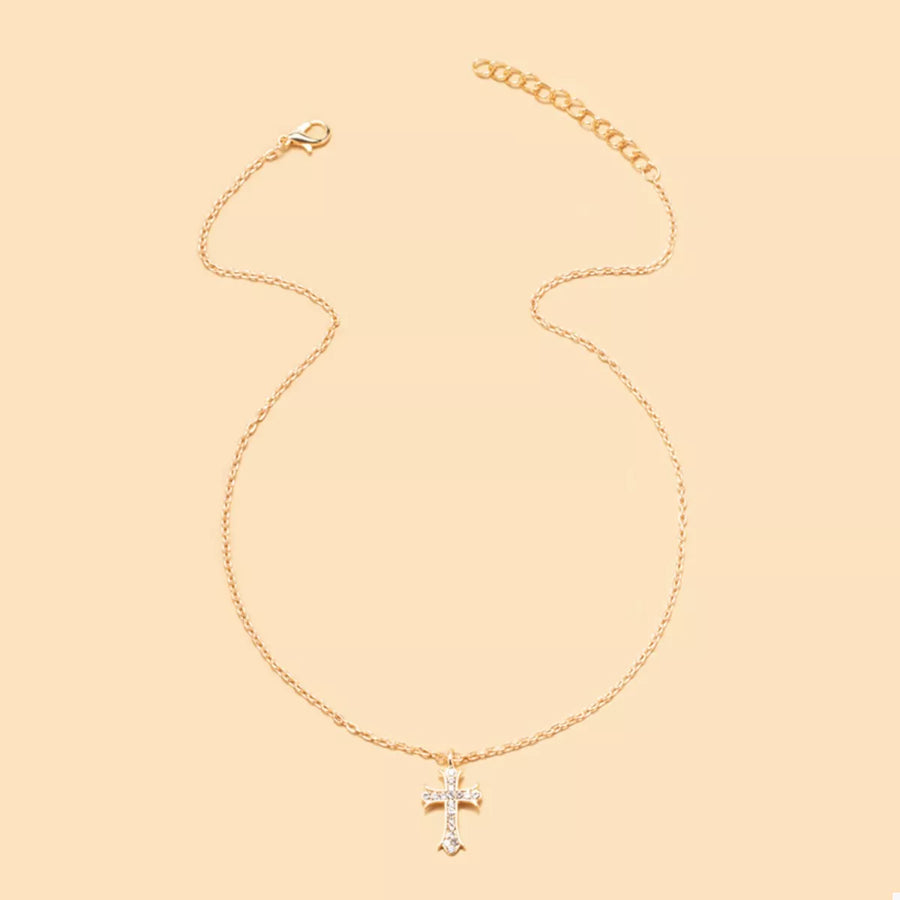 Gold rhinestone cross pendant necklace with a delicate chain.