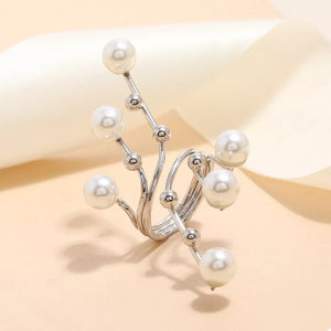 Silver bypass ring with scattered pearls and small silver beads on a swirling metal band.