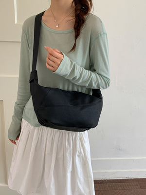 crossbody bag in black featuring adjustable straps and crescent fit