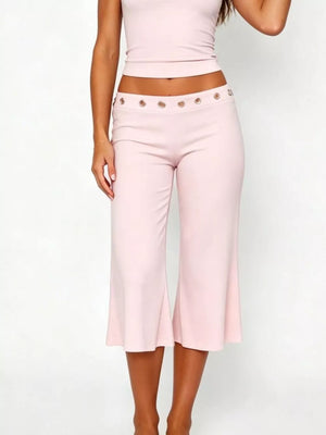 Pink maternity capri pants with flared hem and button detail at the waist.