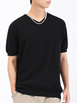 Men's black short sleeve knit t-shirt with a V-neck, styled with a silver chain necklace.
