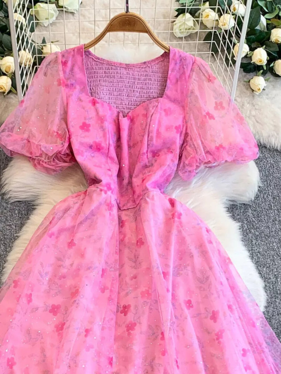Pink floral print maxi dress with sweetheart neckline, puff sleeves, and smocked bodice.