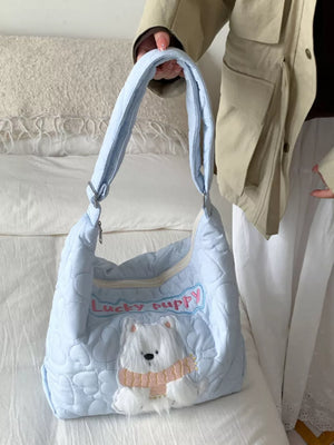 Light blue quilted crossbody bag with white bear applique and "Lucky Puppy" embroidery.