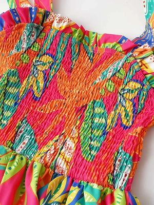 Tropical tie-strap smocked midi dress in strawberry with vibrant leaf print and ruffled neckline.