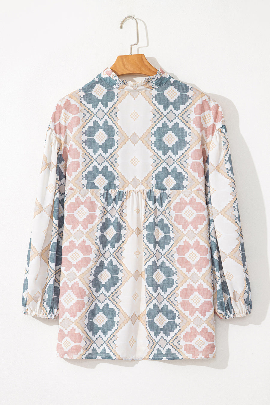 Floral geometric print blouse with ruffled neckline and gathered waist.
