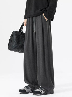 Relaxed fit dark gray sweatpants with drawstring and pockets.