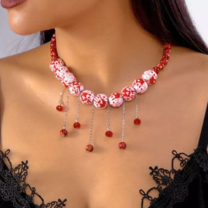 white necklace featuring dangling beads and splatter