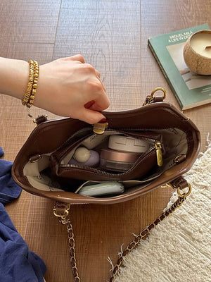light tan crossbody bag with turn-lock and geometric