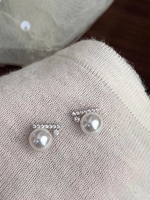 Zircon pearl stud earrings with diamond bar detail in white.