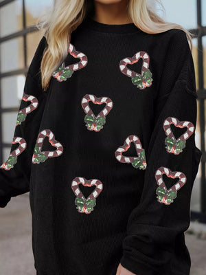 Black crewneck sweatshirt with all-over sequin candy cane heart pattern and green bows.