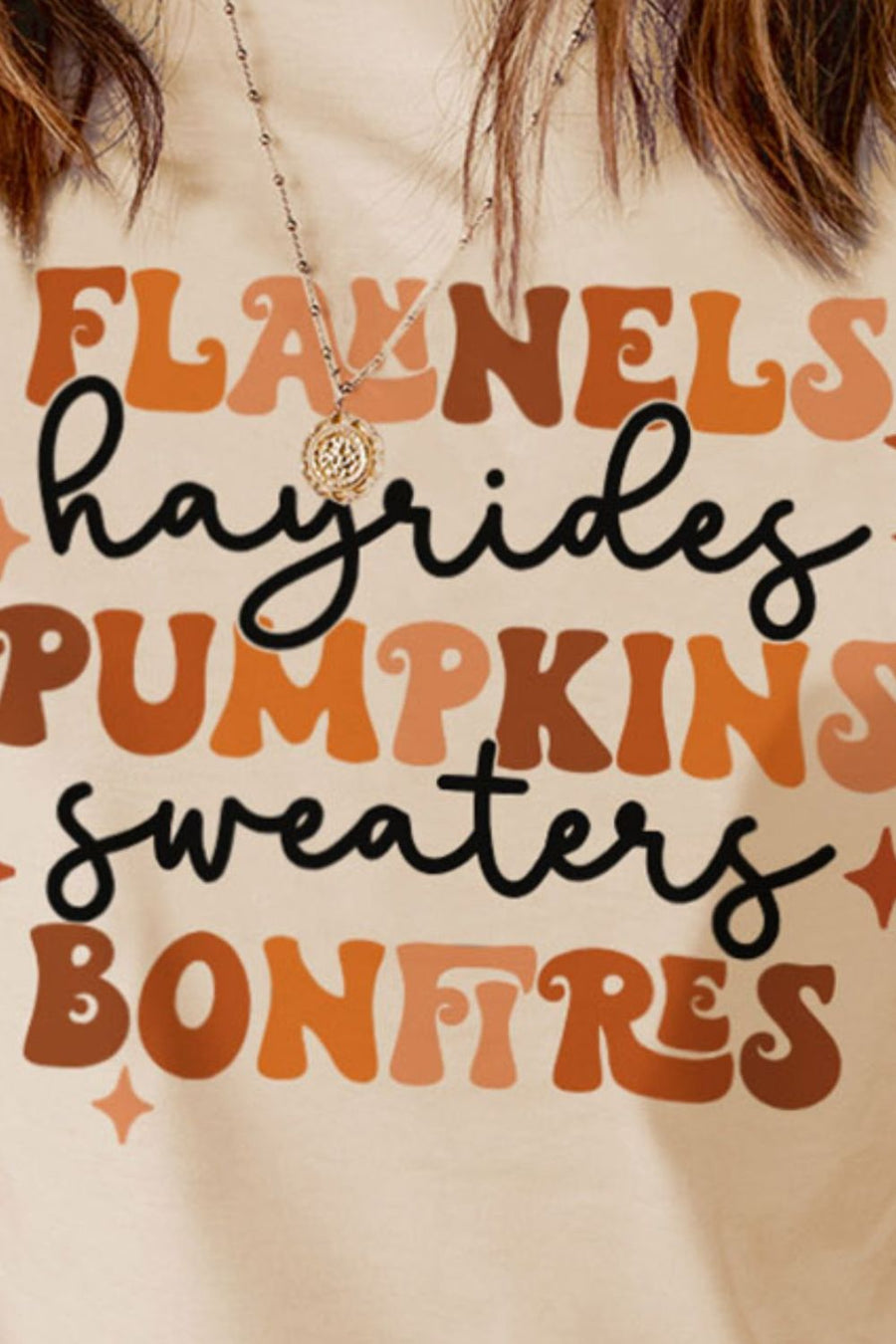 Cream t-shirt with retro graphic text for autumn: flannels, hayrides, pumpkins, sweaters, bonfires.