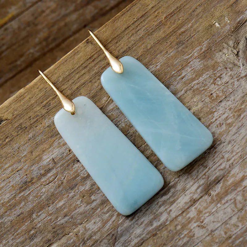 Aqua slab drop earrings in gold with light blue stone pendants.