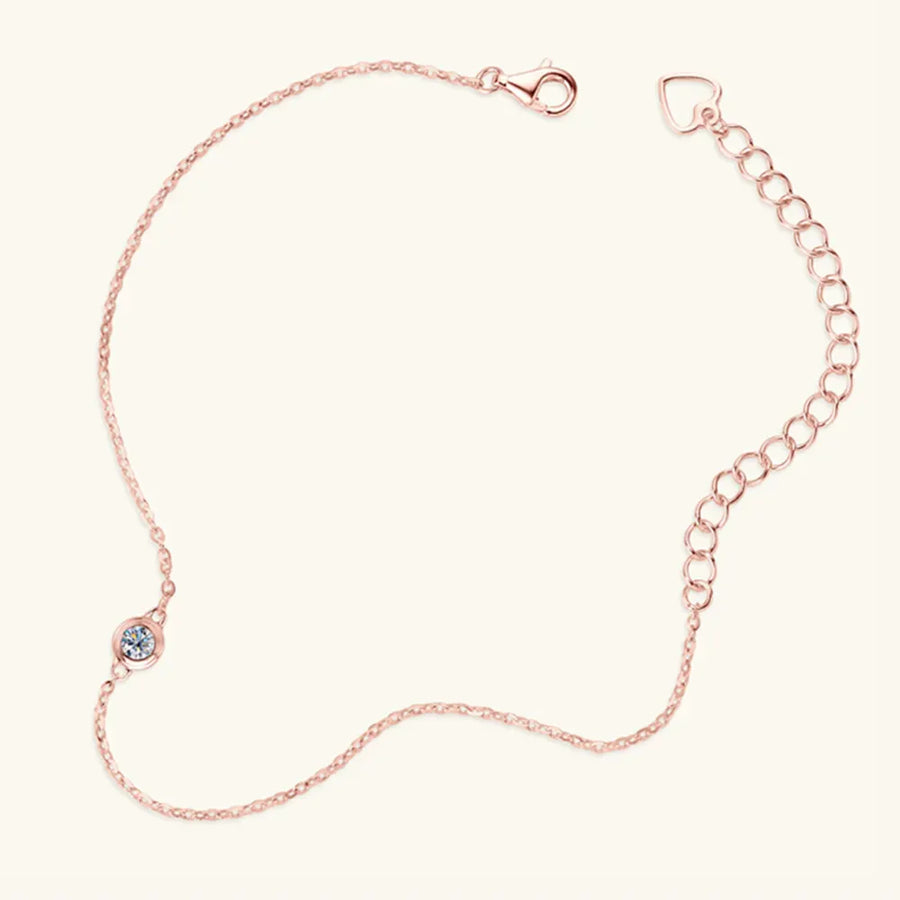 Rose gold chain bracelet with a single moissanite solitaire and heart charm extender.