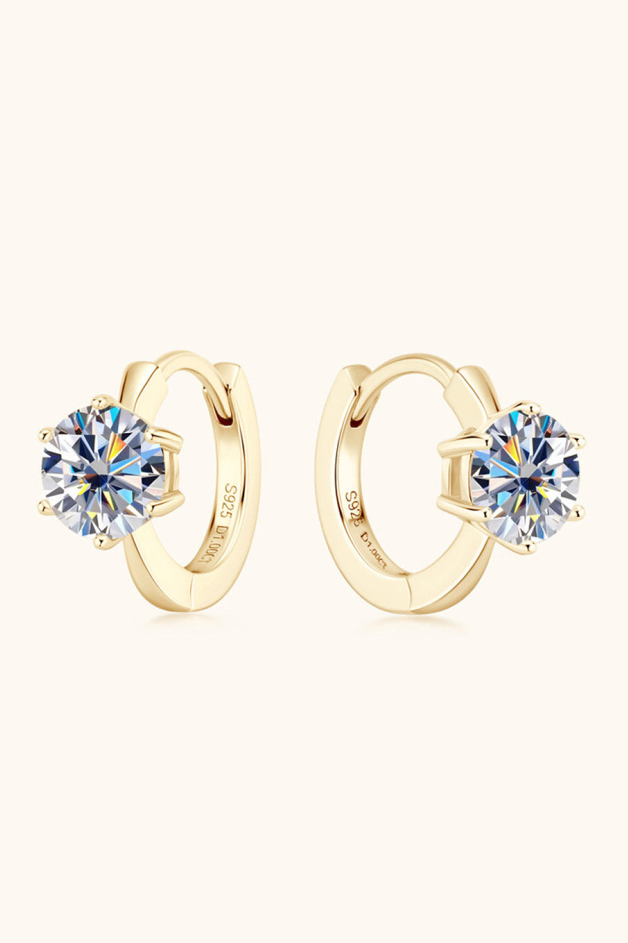 Gold moissanite solitaire huggie hoop earrings with clear round-cut stones.