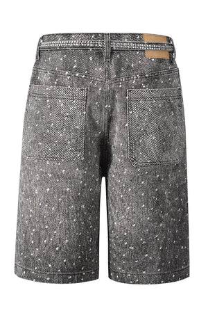 Embellished dark wash denim bermuda shorts with scattered white details and rhinestone waistband.