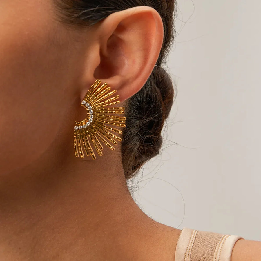 Gold fan earrings with crystal accents and textured rays.