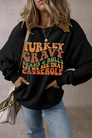 Black crewneck sweatshirt with Thanksgiving graphic text: Turkey Gravy Beans & Rolls Let Me See That Casserole.
