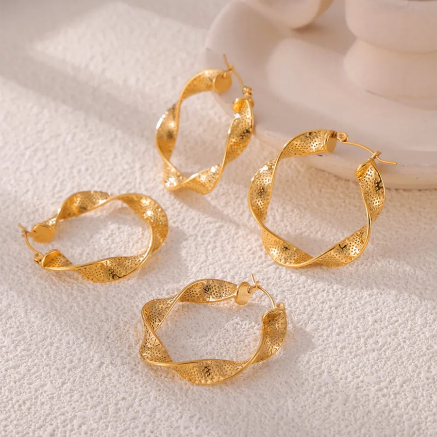 Gold textured spiral hoop earrings with a twisted design and subtle dot pattern.