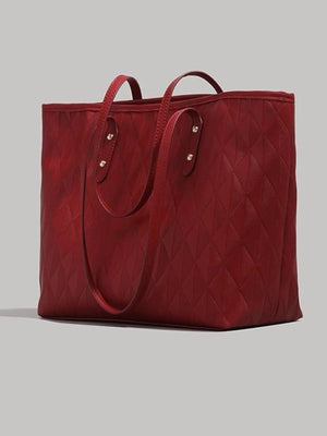 Red quilted pu leather tote bag with diamond pattern and double handles.