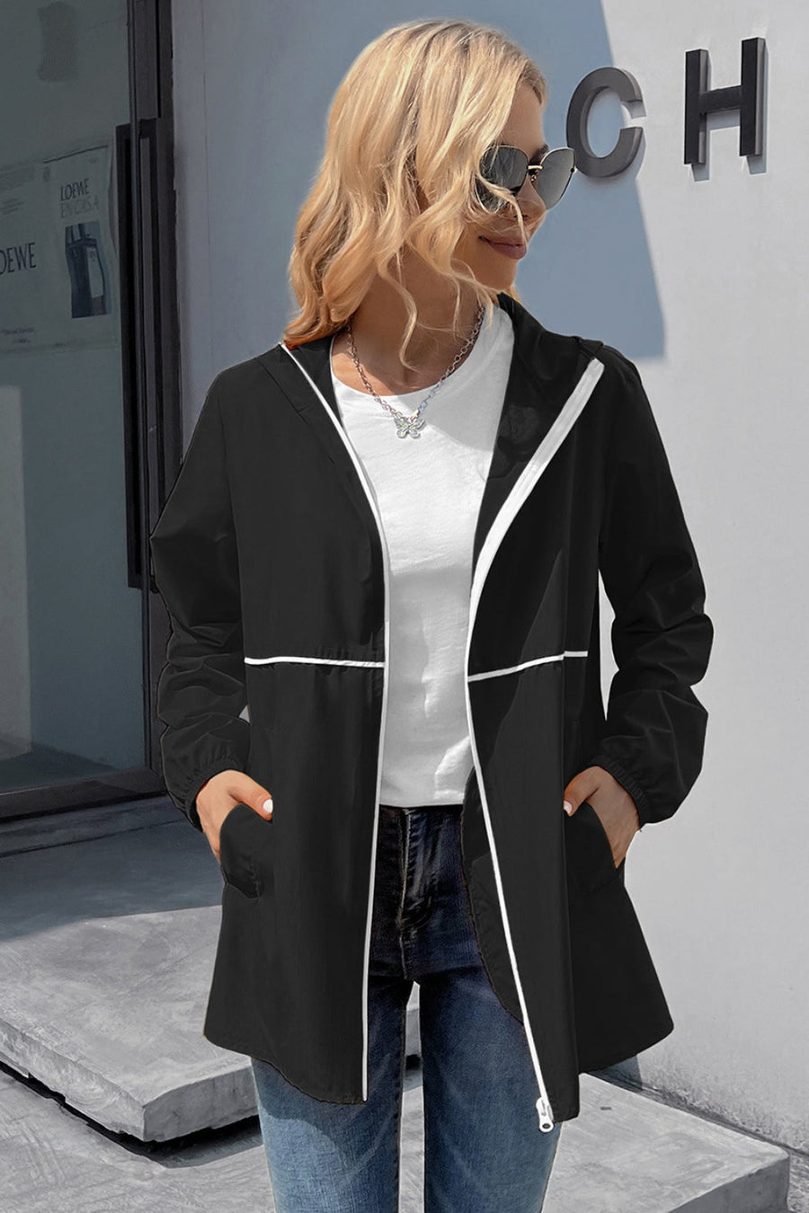 Black hooded rain coat with white trim and zipper detail.