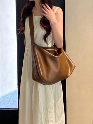 Large brown pu leather crossbody bag with a slouchy silhouette and zipper closure.