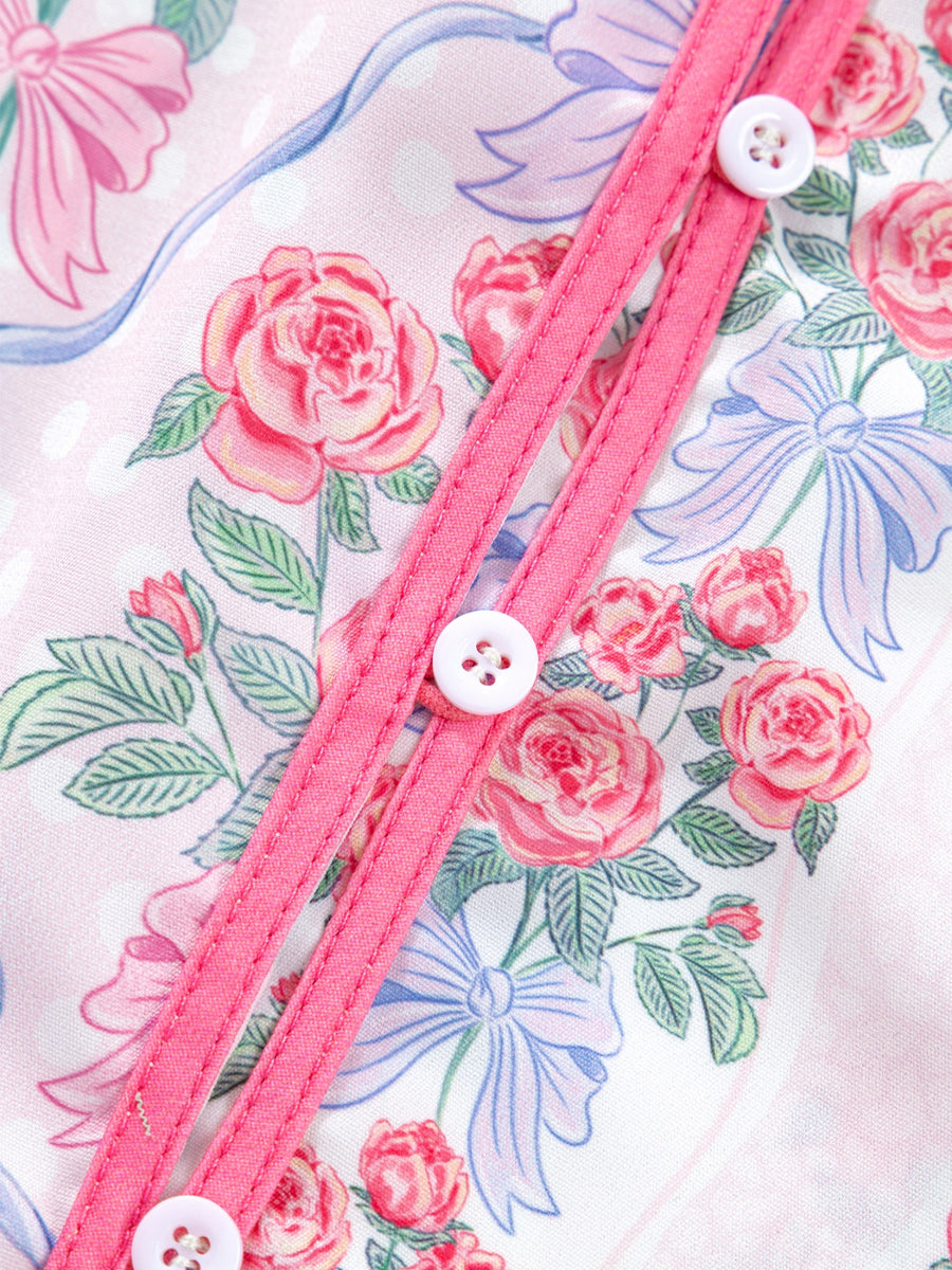 Maternity shirt with pink roses and blue bows pattern, button-up front with white buttons.