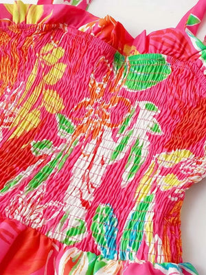 Tropical tie-strap smocked midi dress in strawberry pink with a floral print and ruffled neckline.