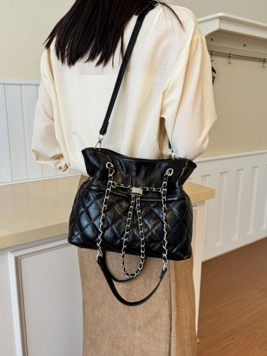 Black handbag featuring quilted and quilted