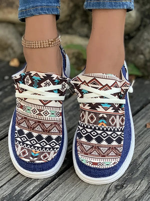 Aztec print canvas slip-on shoes in light indigo with white laces and a white sole.