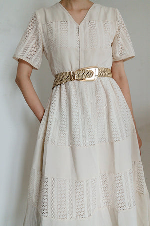 Woven raffia belt with gold-tone buckle, styled with a white lace dress.