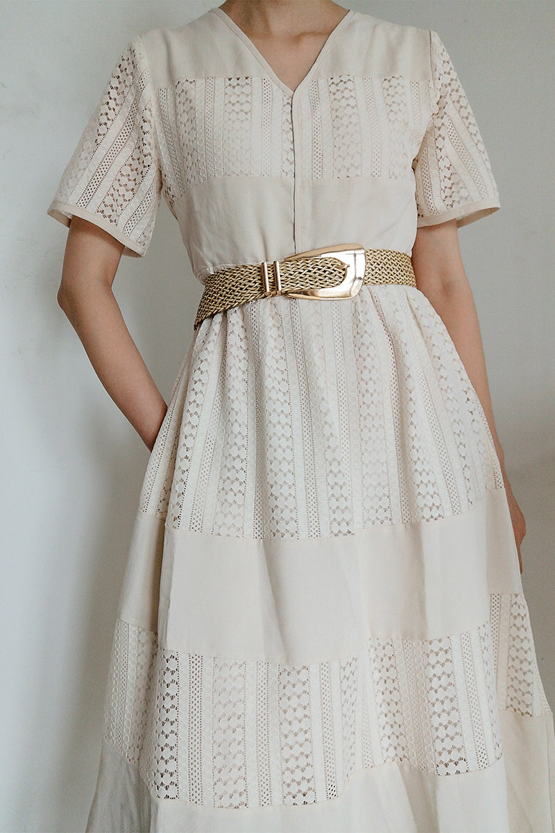 Woven raffia belt with gold-tone buckle, styled with a white lace dress.