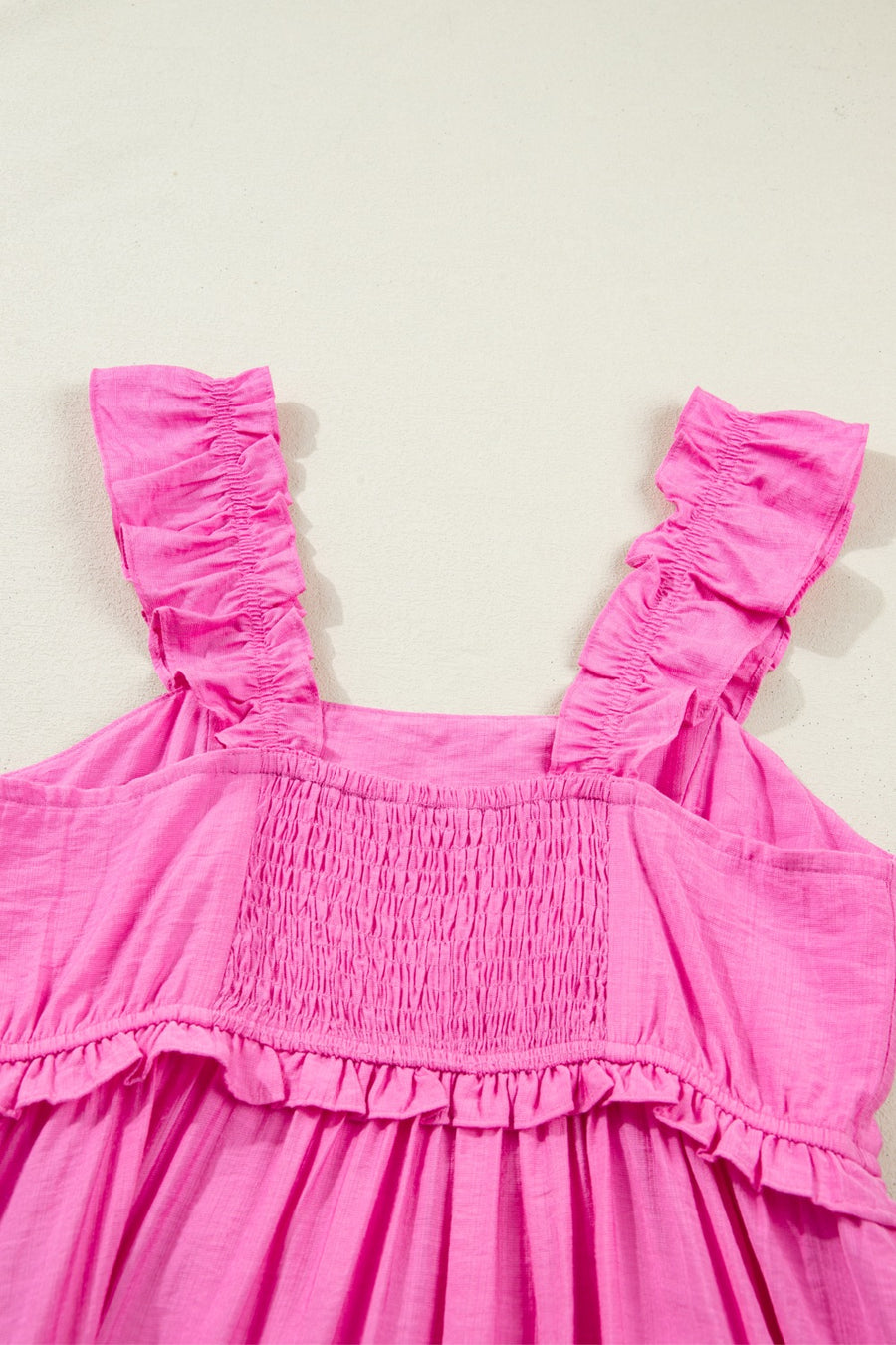Pink ruffled sleeveless maxi dress with smocked bodice and tiered hem.