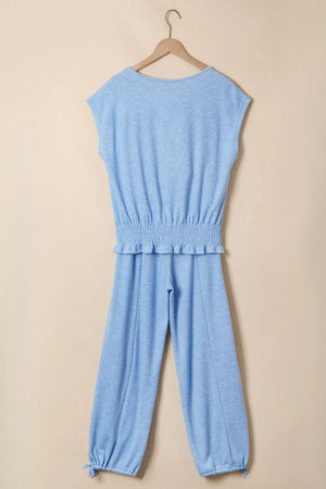 Light blue knit cap sleeve top with smocked waist and jogger pants with drawstring cuffs.