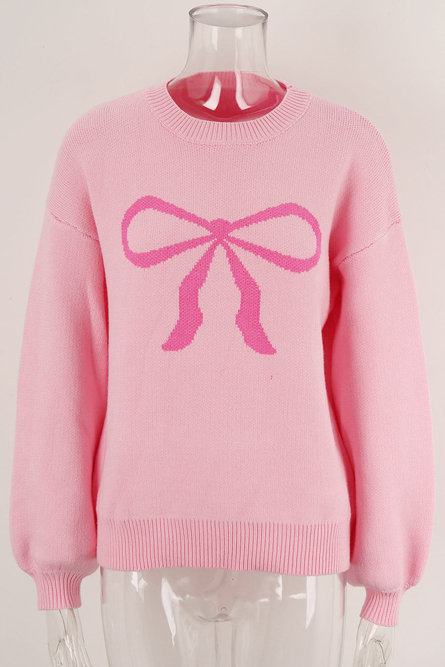 Blush pink acrylic sweater with a graphic pink bow intarsia pattern and crew neck.