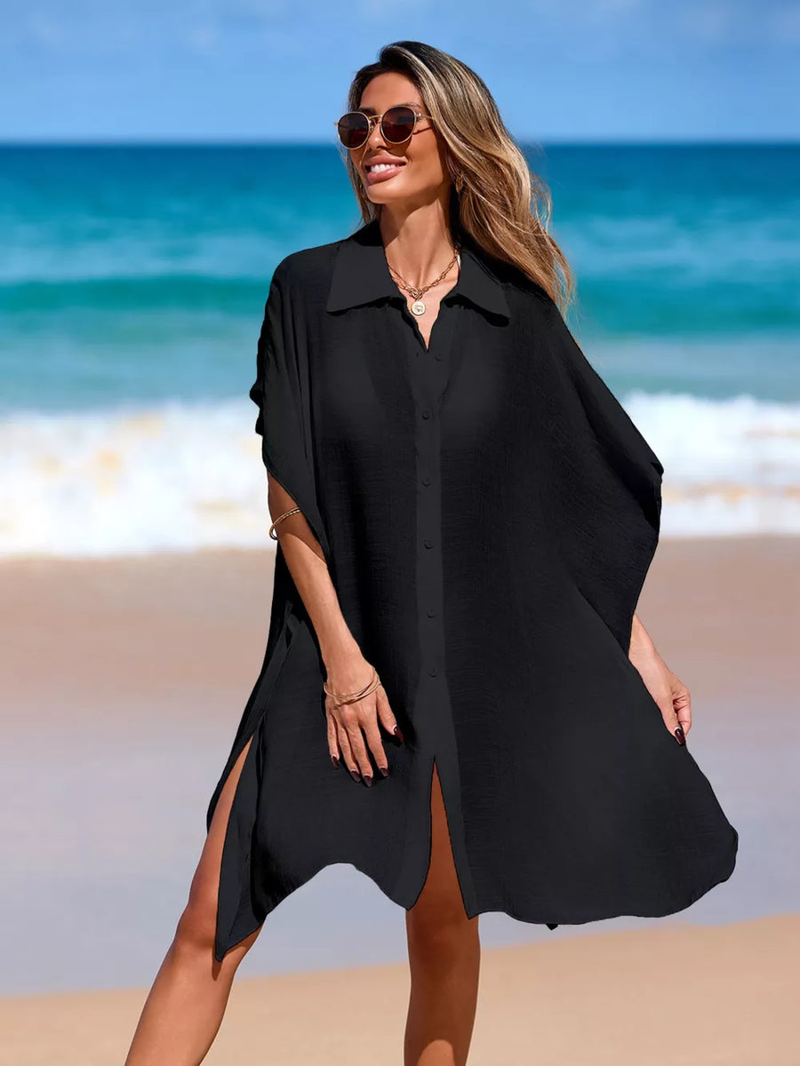 Black button-up cover-up with short sleeves and high side slits, worn at the beach.