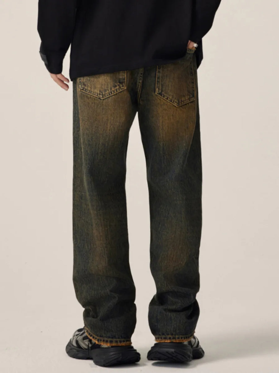Men's relaxed fit jeans in vintage wash cotton with distressed details.