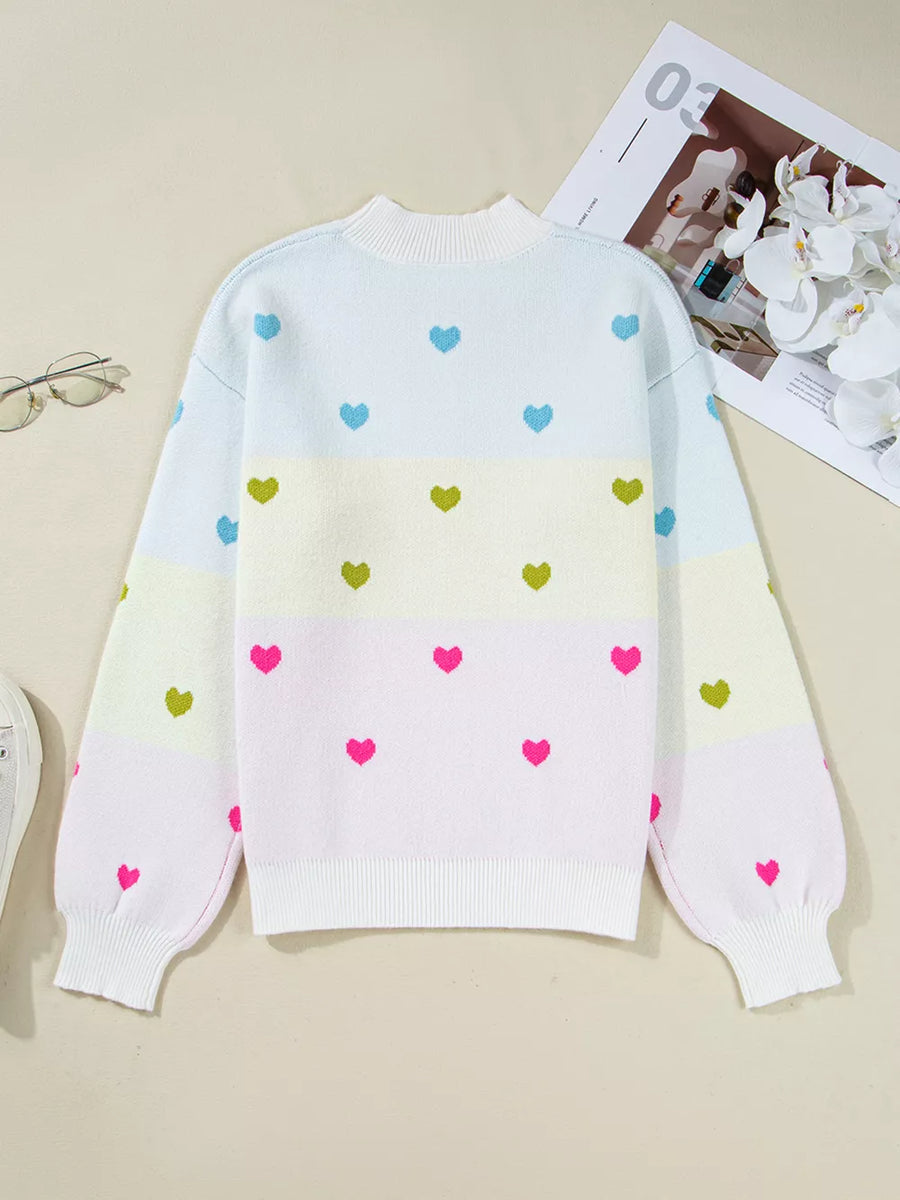 Women's crew neck knit sweater with colorful heart pattern and pastel stripes.
