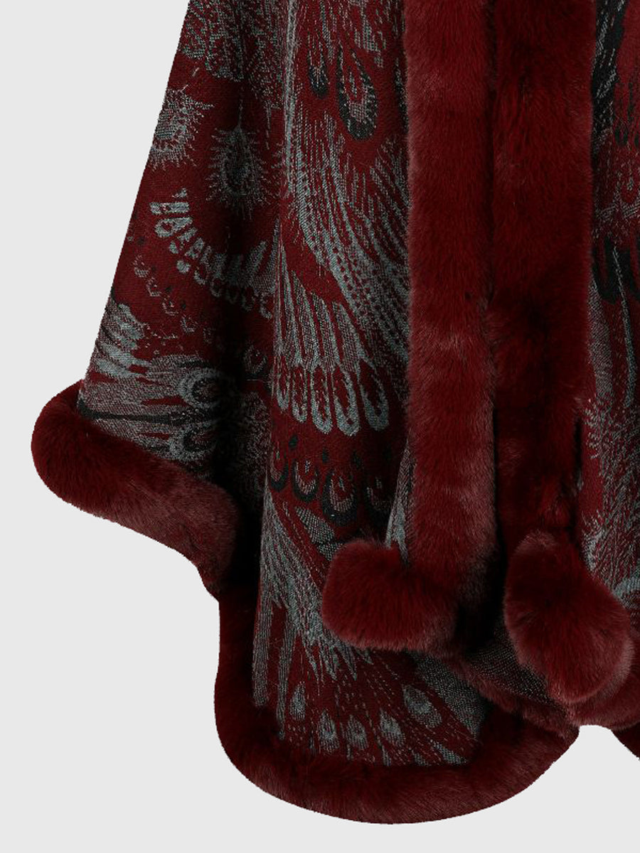 Wine feather print cape with faux fur trim and pom poms.