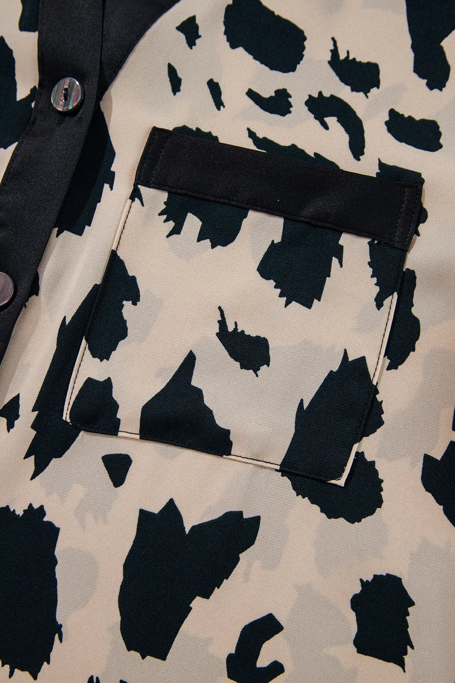 Animal print satin pajama shirt with black trim and pocket detail.